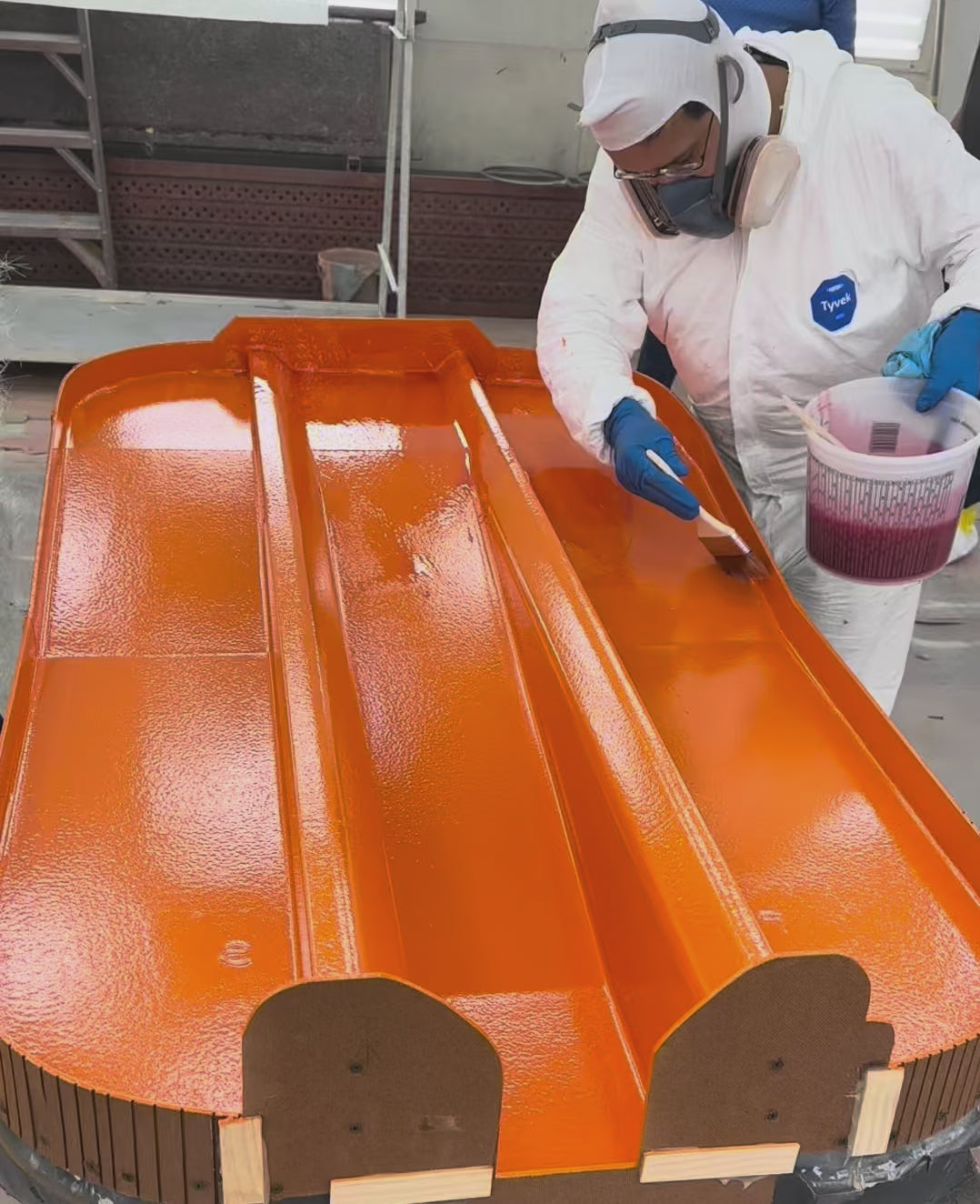 Someone applying laminating resin over a composite mold